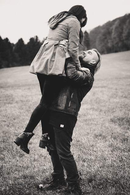Mann hebt Freundin auf der Wiese, schwarz weiß