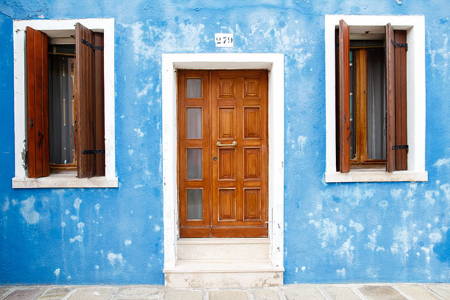 blaue Fassade mit Holztür
